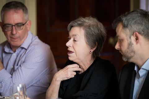 Photograph focused on Medco Registration solutions director Susan Brown in conversation at the roundtable. She wears a black top, black studded earrings and plum lipstick.